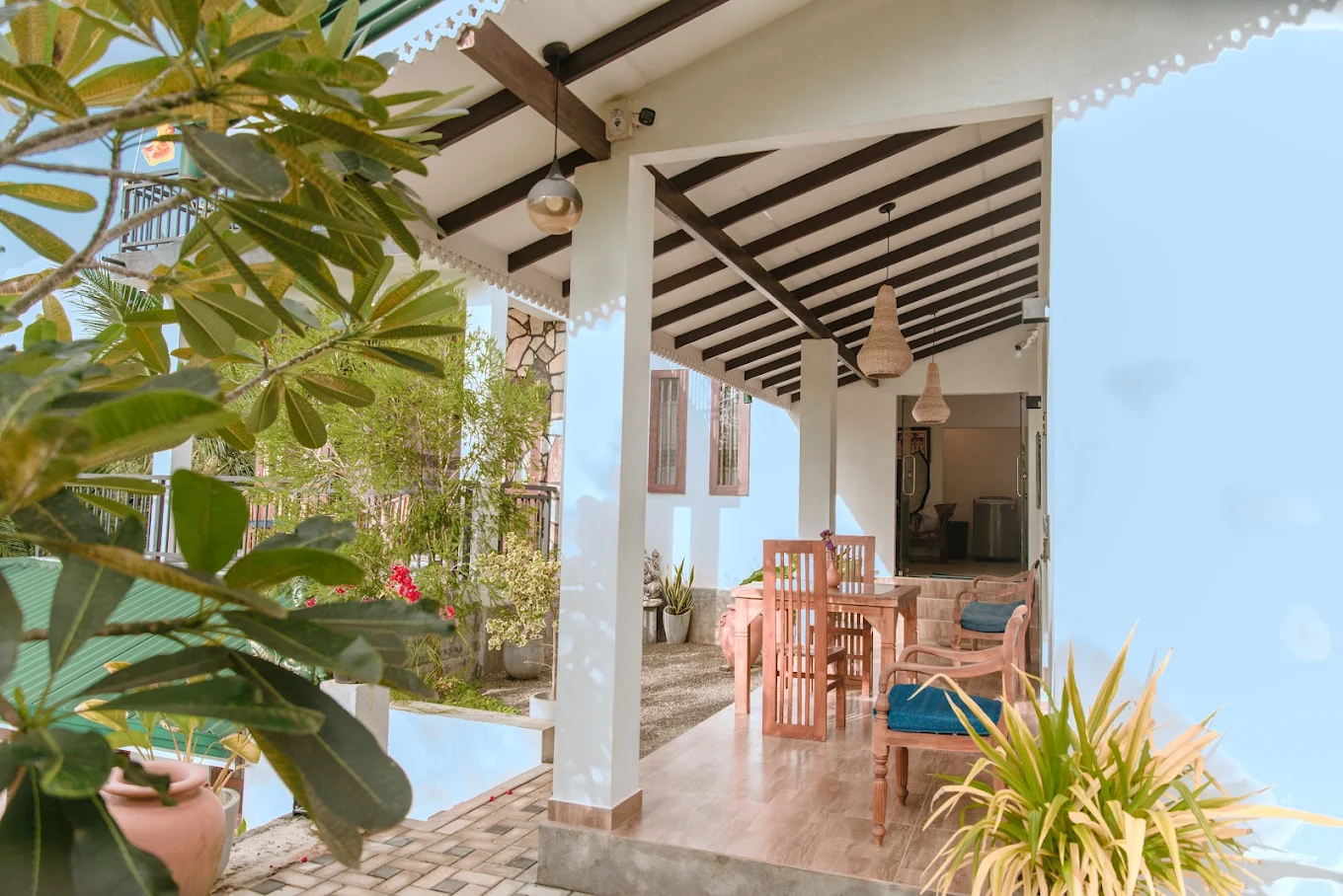 Shaded veranda with wooden seating and tropical plants at Monkey Island Villa