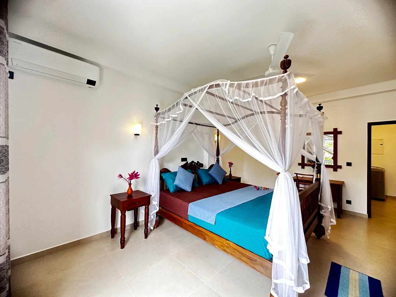 Guest bedroom with blue bedding and a canopy bed at Monkey Island Villa